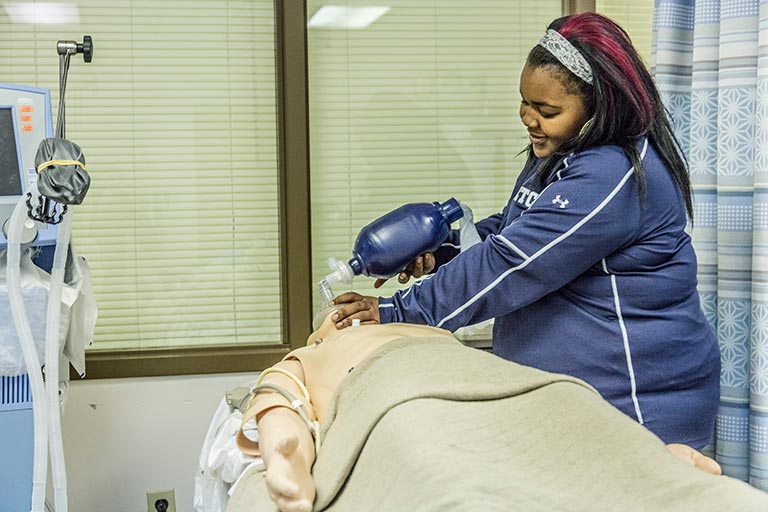 nursing student putting oxygen over mannequin's face