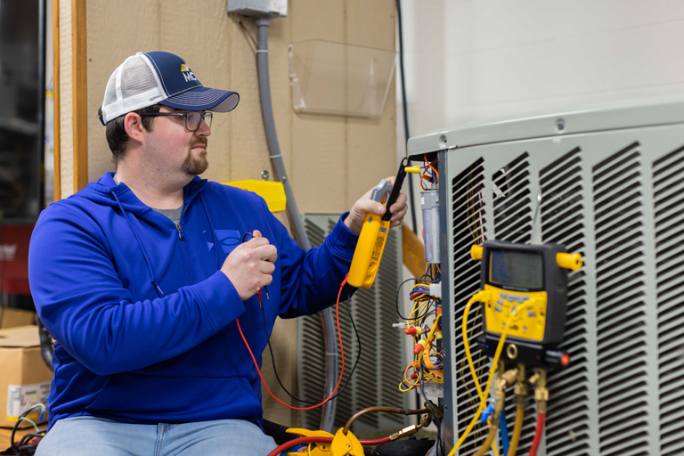 student working on HVAC unit