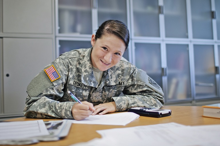 woman in military uniform taking notes and smiling