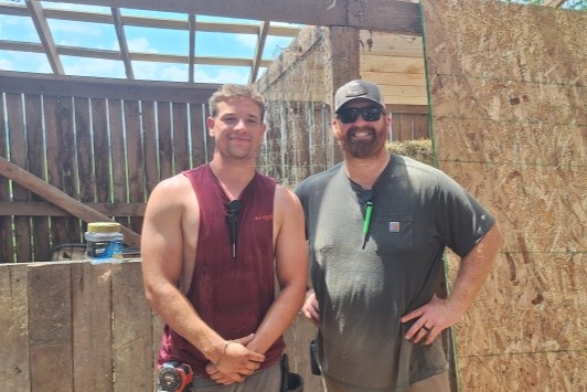 Derek Stevens and another person in front of a construction project