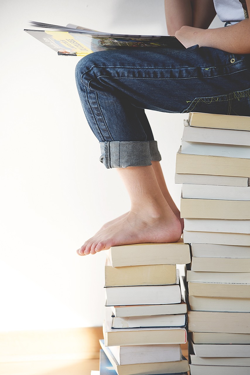 Person reading on a pile of books