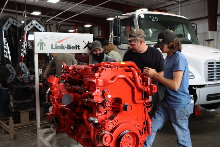 3 students working on an engine