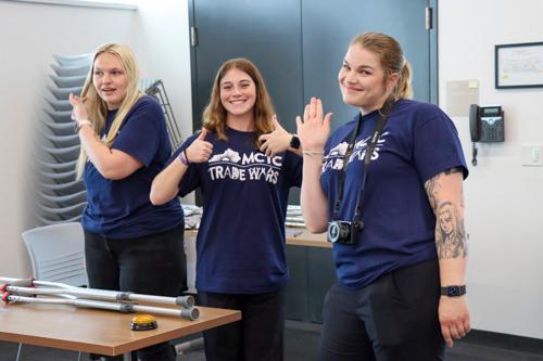 three students wearing Trade Wars t-shirts