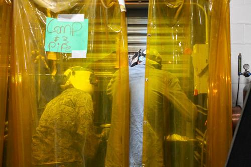 two people behind a gold curtain for a pipe welding competition