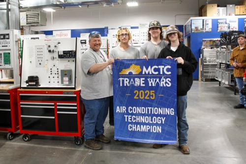four students holding a banner for their win in the Air Conditioning Technology competition