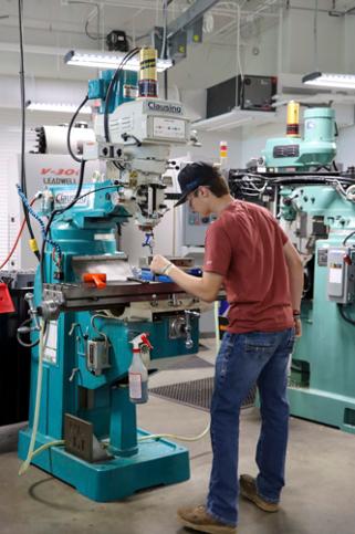 a student watching a 3d printer