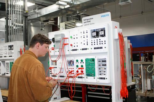 student working on a large upright circuit board