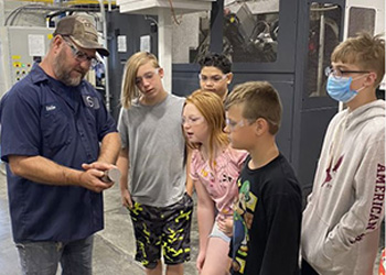 Stober Drives employee showing mechanical items to kids at Career Craze 2022 in a technical lab on the Maysville Campus.