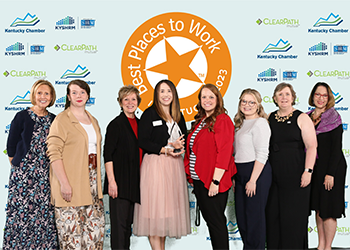 Eight employees in front of Best Places to Work in Kentucky photo background holding the Best Places to Work in Kentucky award.