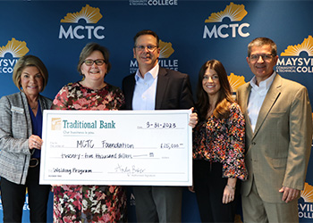 Traditional Bank check being presented to MCTC representatives.