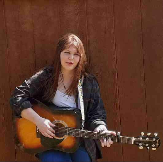 Allison Walker playing her guitar