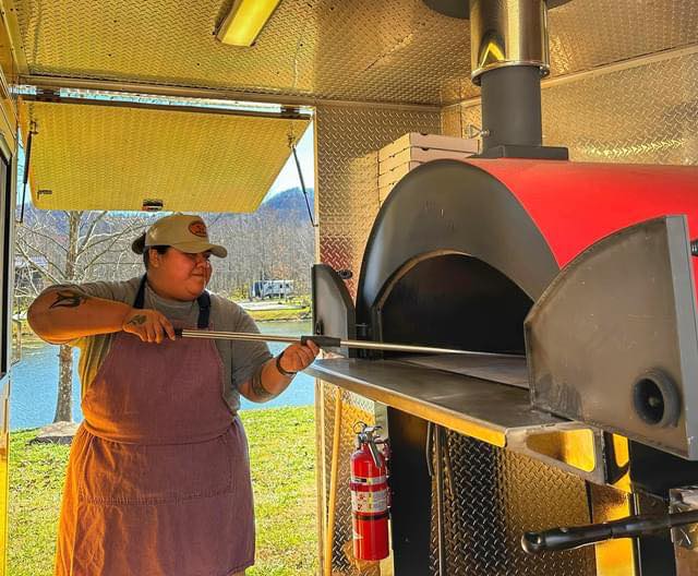 Megan Lewis using a pizza oven in the food truck