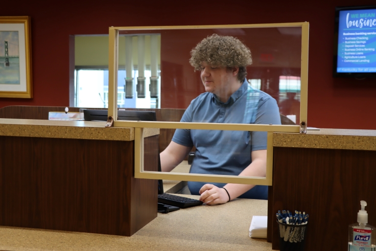 Colby Hurst at a teller counter at the bank