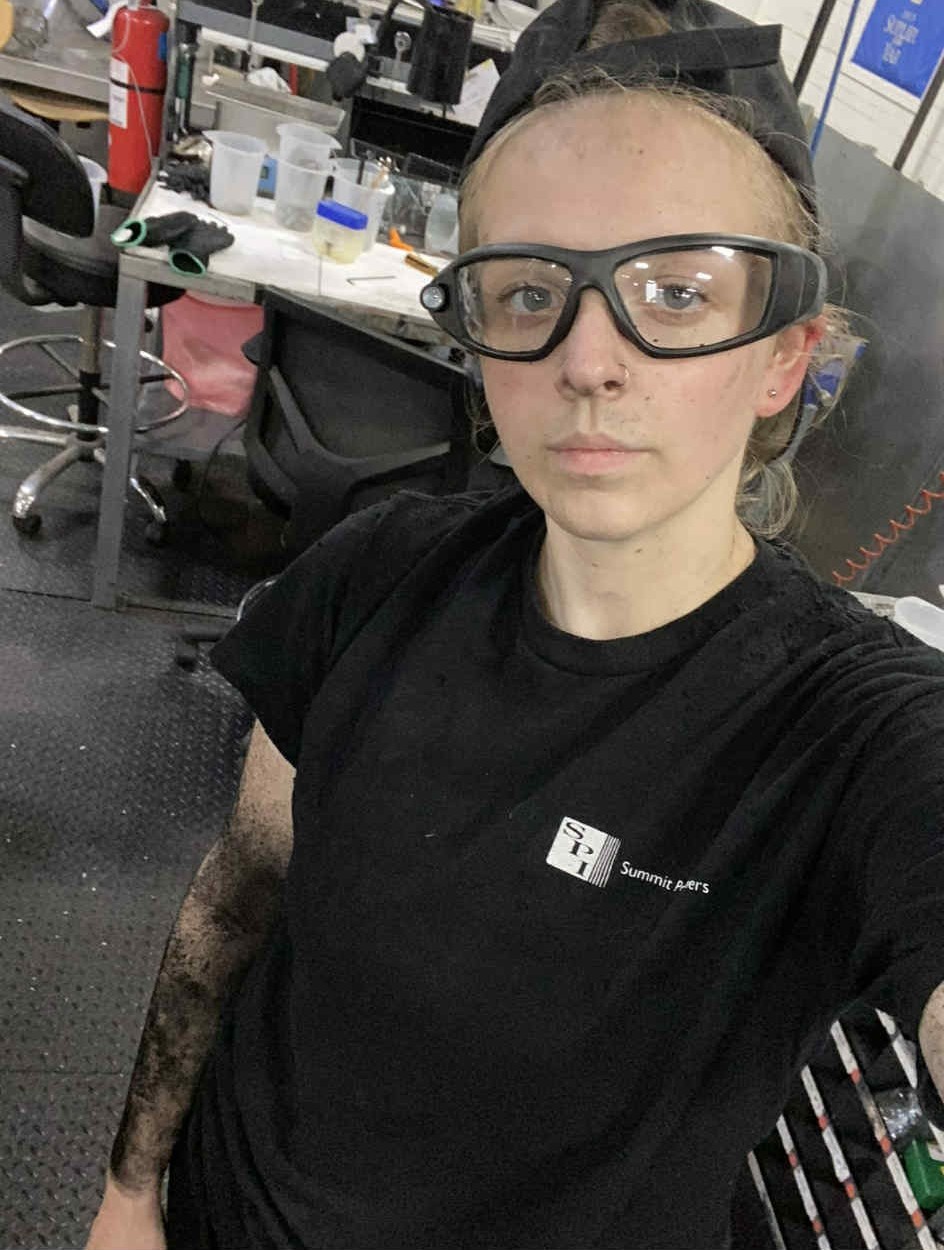 Hannah Ingram wearing Summit Polymers black T-shirt and safety glasses.