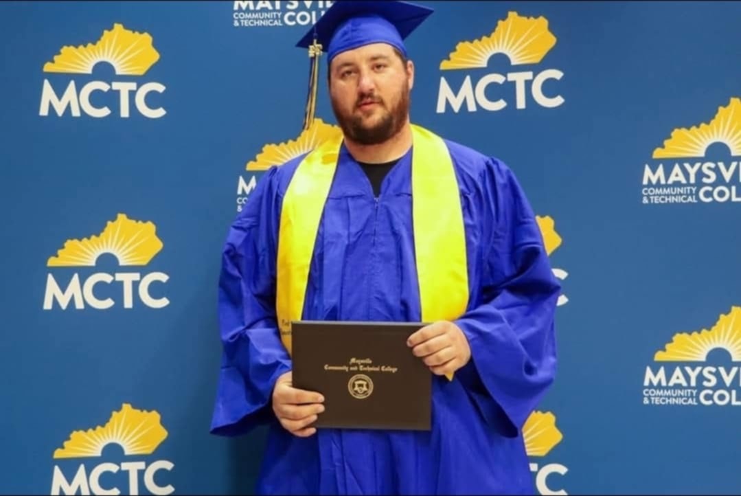 Justin Rogers in graduation attire, holding a certificate