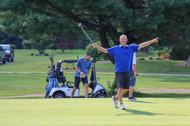 three men on a golf course holding clubs