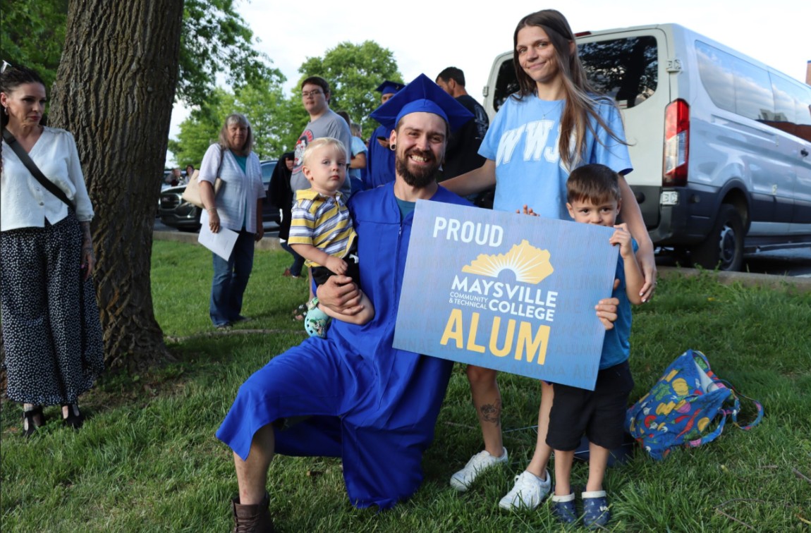 graduate in his cap & gown with his family and a 