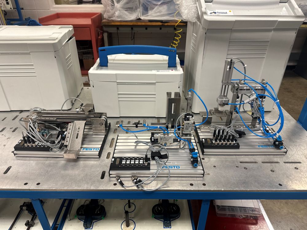 Mechatronics equipment on a table. Gray box with blue cords.