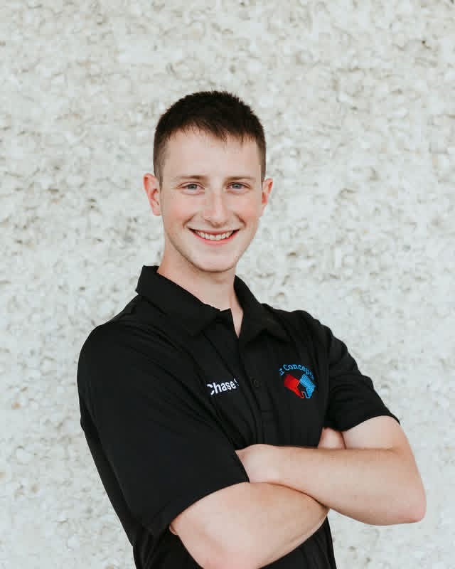 Headshot photo of Chase Stafford, wearing black polo shirt with arms crossed.