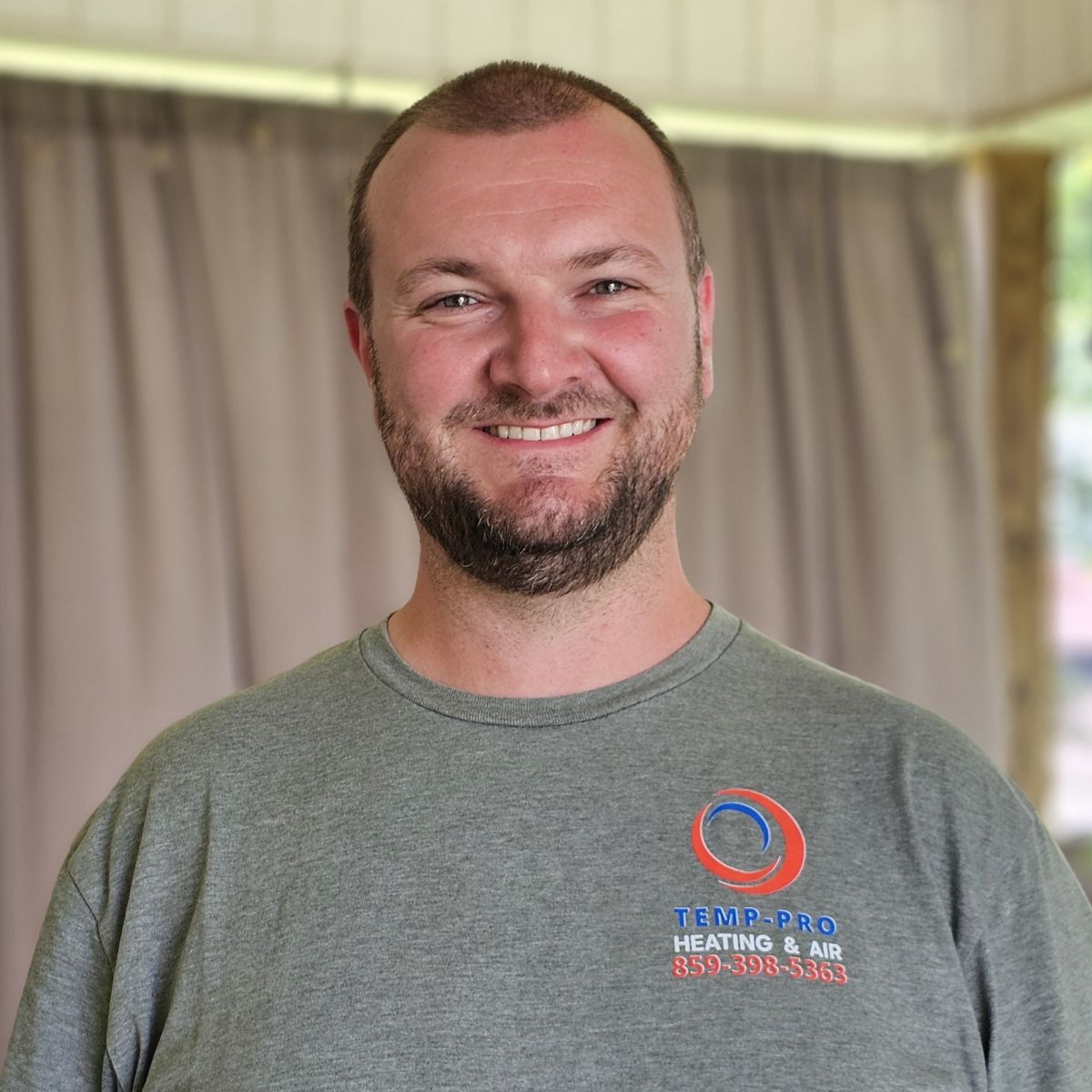 Headshot photo of Jacob Williams wearing a gray shirt with the Temp-Pro Heating & AIr logo on it.